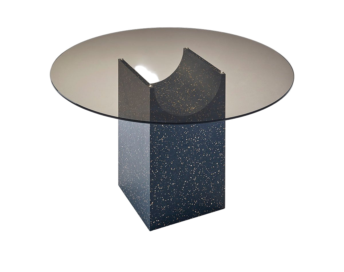 Modern round glass table with a unique base design on a white background