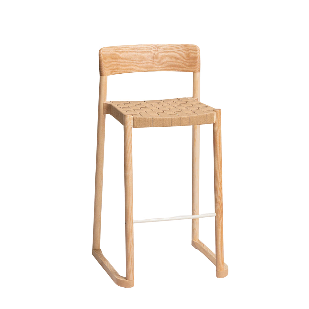 Wooden bar stool with woven seat on a light gray background